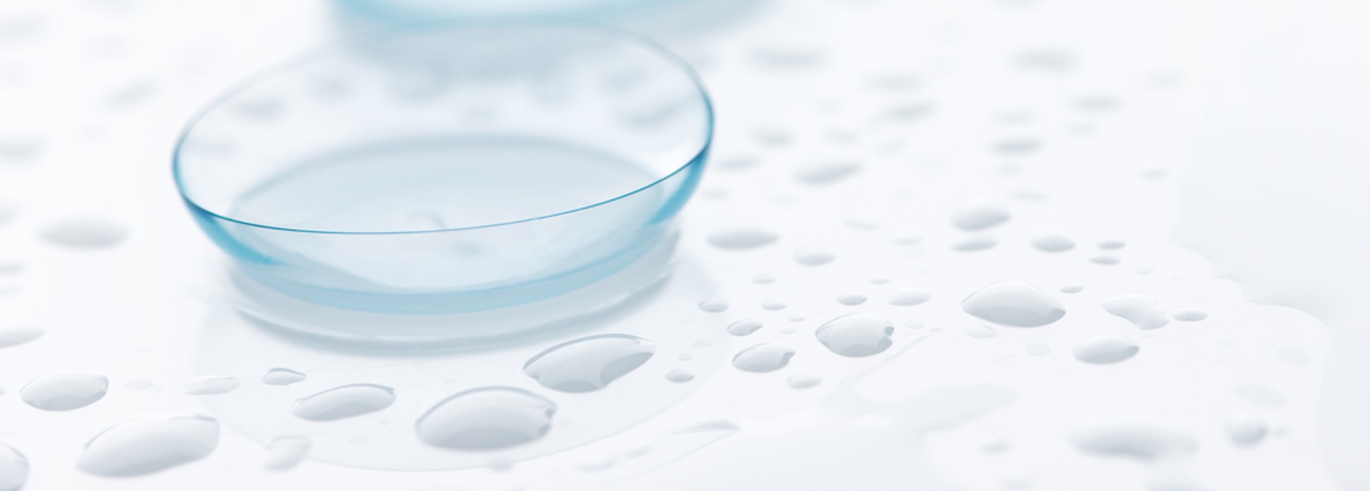 a contact lens on a surface with some water droplets