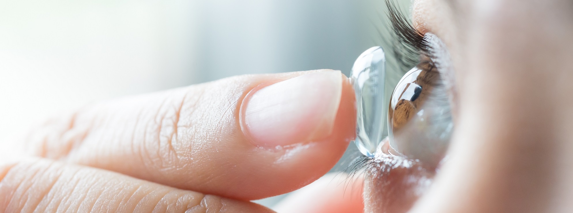 a woman inserting a contact lens