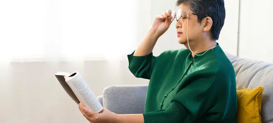 Woman with age related macular degeneration reading