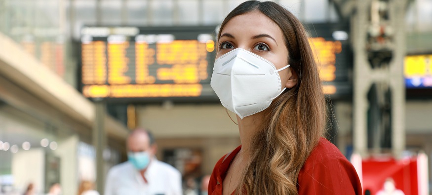 a woman wearing a face mask at the train station