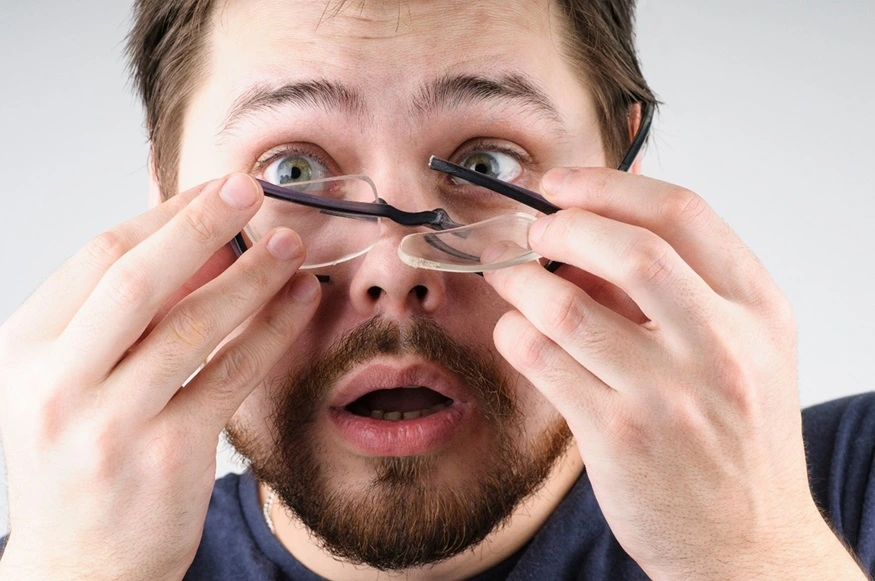 Man with a pair of broken glasses