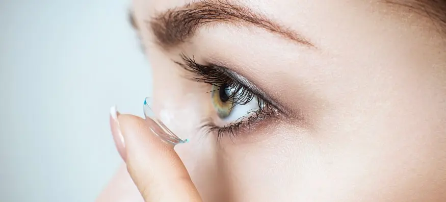 woman applying contact lenses min