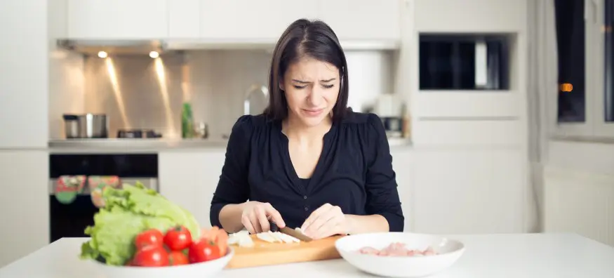 woman chopping onions crying