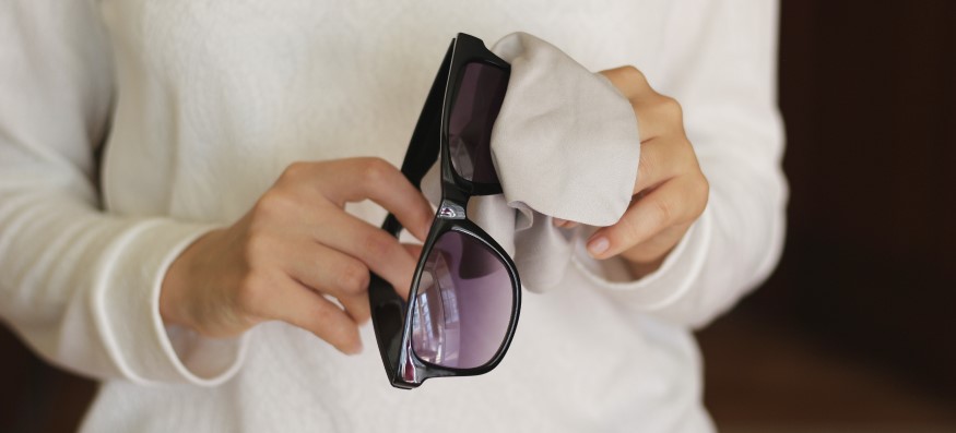 woman cleaning sunglasses