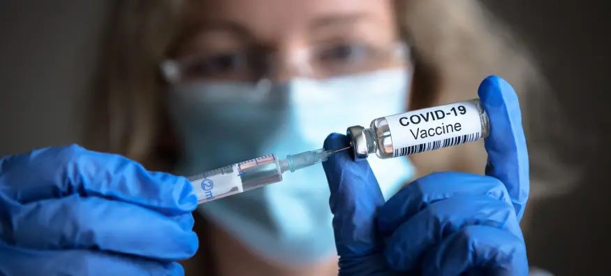 woman holding covid 19 vaccine